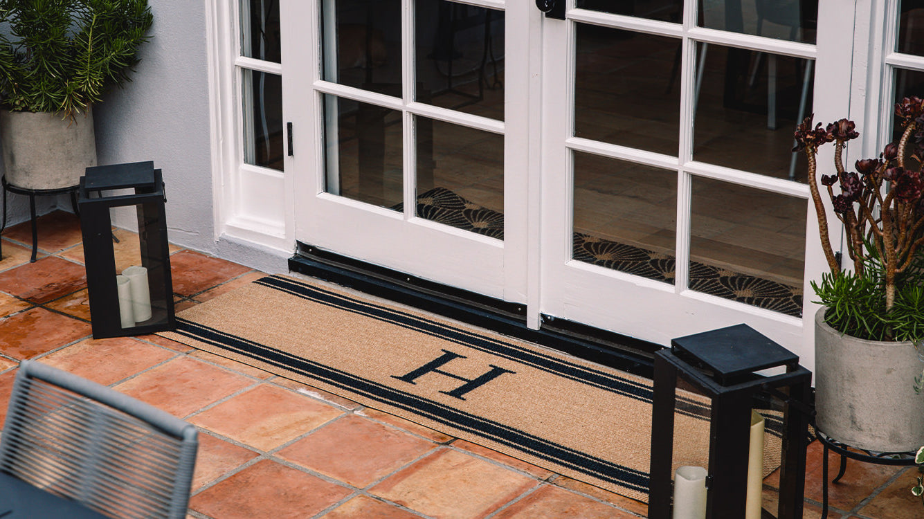 Double door Neighburly mat personalized with your middle initial in the center of a non-shedding surface.