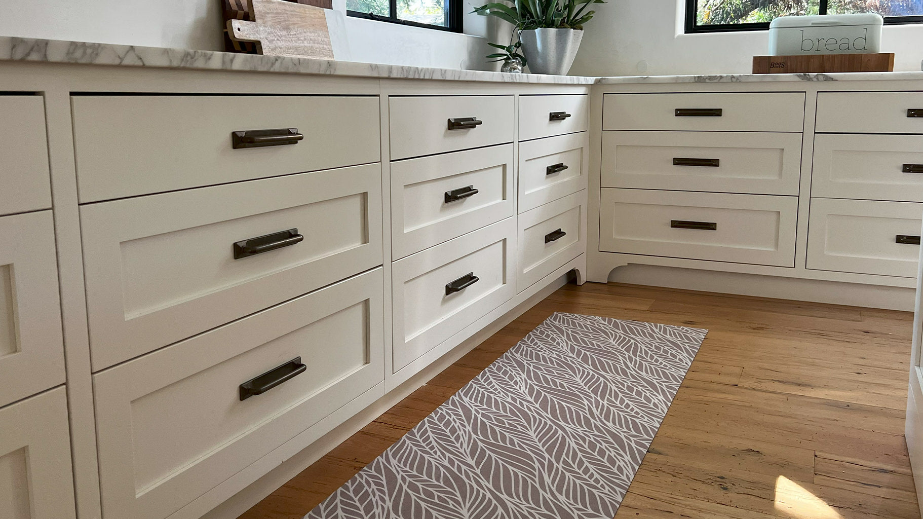 Thin Un-Rug kitchen mat runner is placed at the base of long kitchen counters to protect natural wood floors.