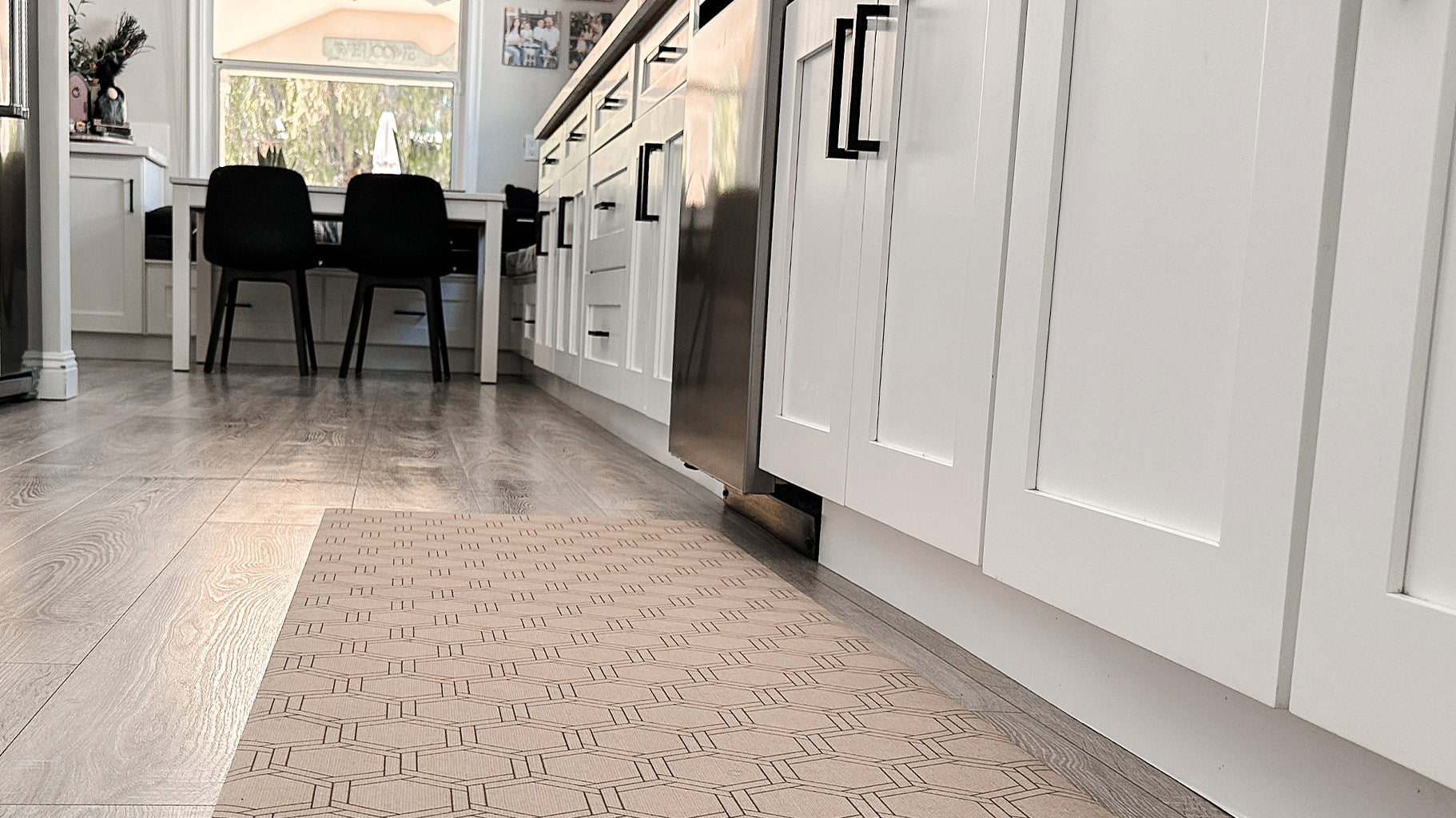 Low-Profile Un-Rug kitchen runner mat in honeycomb pattern placed in front of a dishwasher.