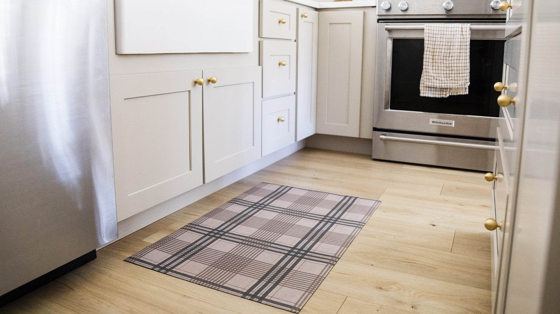 Un-Rug kitchen mat in a traditional plaid pattern is placed at the base of a farmhouse style kitchen sink.
