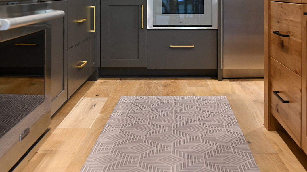Decorative Un-Rug kitchen mat runner is placed in front of a kitchen sink to protect floors from spills and water.