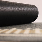 Image of the rubber backing rolled up on Corner Lot’s non shed personalized grey surface.