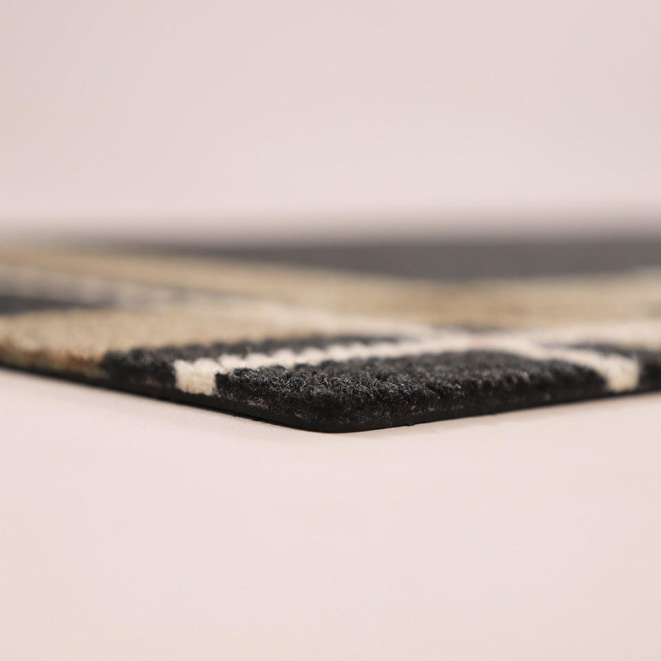 Close-up corner shot of Corner Lot’s low profile and non shedding, black, white, and army surface backed by rubber.