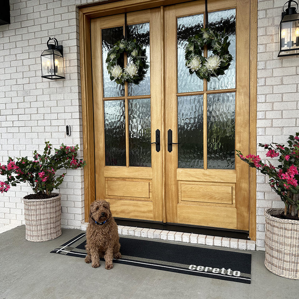 Neighburly's Coner Lot double door entrance mat personalized with a last name with a cute dog sitting on it.