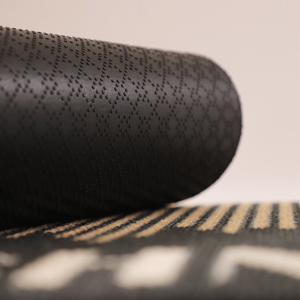 Image of the rubber backing rolled up on Fall in Line’s non shed personalized black surface.