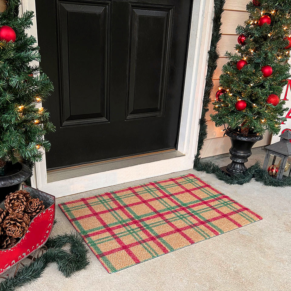 Holiday Glen Christmas plaid mat of green and red on a coir color in front of a door.