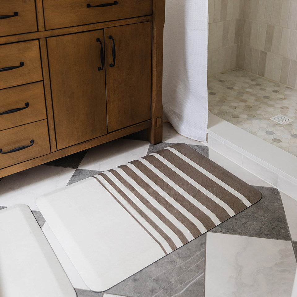 Happy Feet Asymmetrical Stripe anti-fatigue cream colored mat with brown stripes on a wipeable surface.