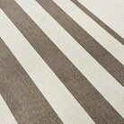 Close up of canvas-like textured mat with cream and light brown stripes in various sizes.