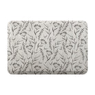 beautiful anti-fatigue mat with brown botanical design on a beige canvas-like textured background.
