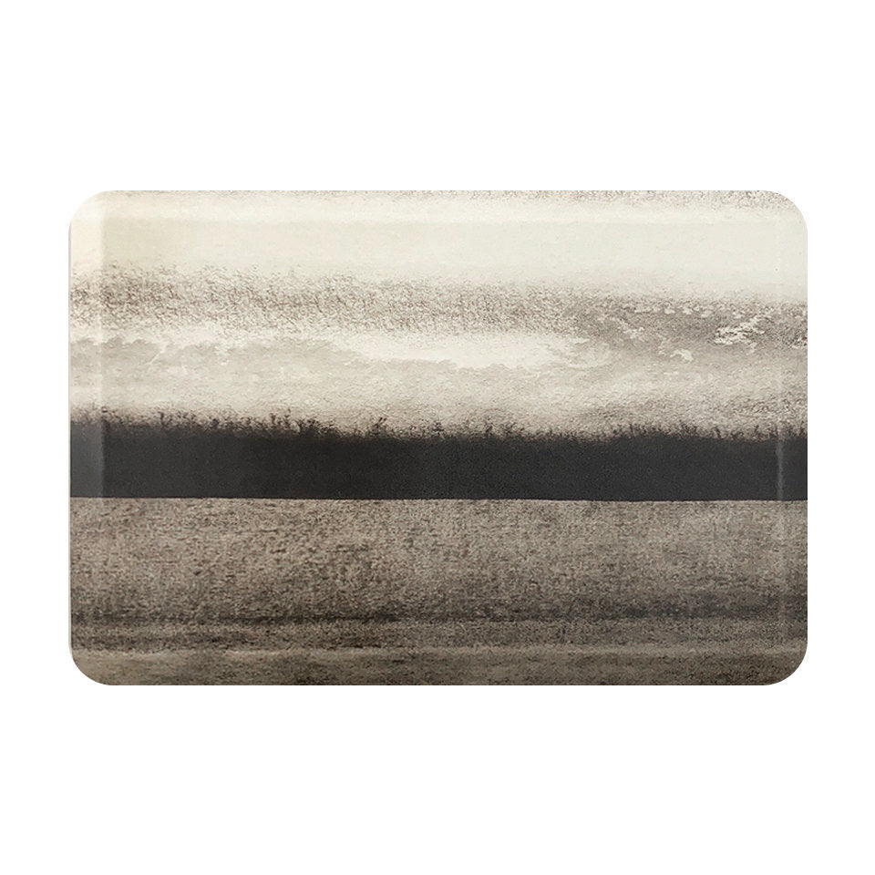 Overhead of Moody Hues anti-fatigue mat with a misty landscape design in high-definition print of black, grey, and creams.