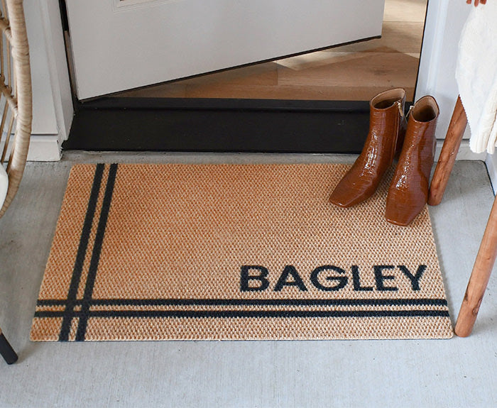 Personalized entrance mat in front of an open door.