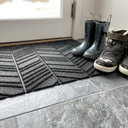 Matterly In-Vein single door mat placed at the back door with snowy boots placed on top. These are all-weather doormats and are made in the USA.