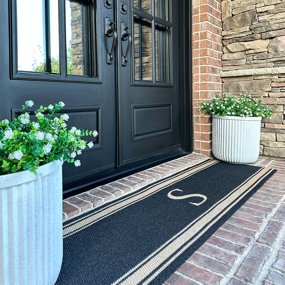 Low-profile Initial Stripes coir on black double door indoor mat monogrammed with the letter S.