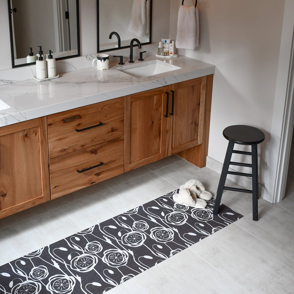 Low-profile and machine washable Peonies repeating pattern, urbane bronze background, peonies in cream on a bathroom floor
