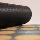 Image of rubber backing rolled up on an aqua, coir, and grey Luckly Numbers mat.