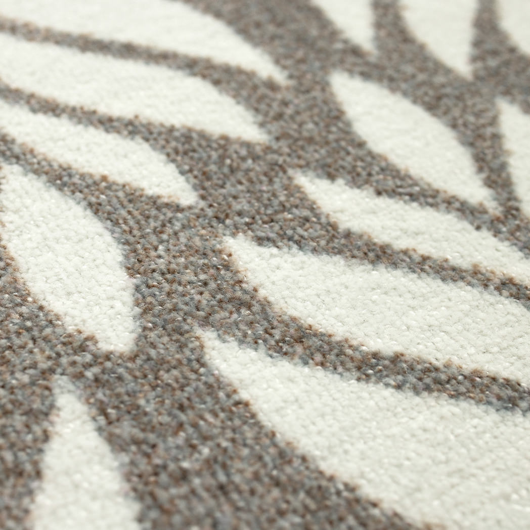 Close-up of the Maxcent Botanica mat featuring a soft brown and gray leaf pattern on a light cream background. The textured carpeted surface offers a comfortable feel underfoot, with a high-contrast design that adds a natural, decorative touch.
