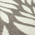 Close-up of the Maxcent Botanica mat featuring a soft brown and gray leaf pattern on a light cream background. The textured carpeted surface offers a comfortable feel underfoot, with a high-contrast design that adds a natural, decorative touch.