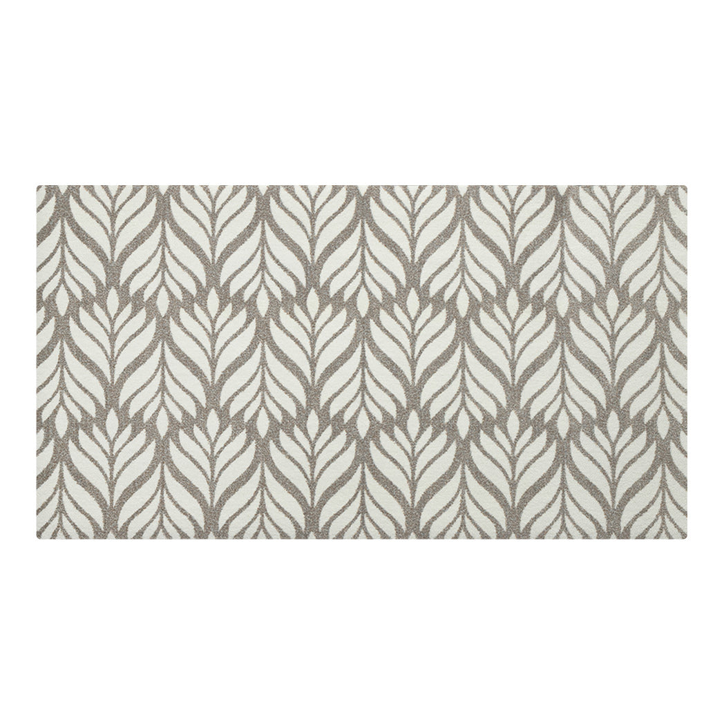 Maxcent Botanica area mat in Light Greige, medium size – features a soft brown and gray leaf pattern over a light cream background. The elegant, nature-inspired design adds warmth to any space, while the carpeted surface and non-slip backing combine comfort with stability on hard floors.
