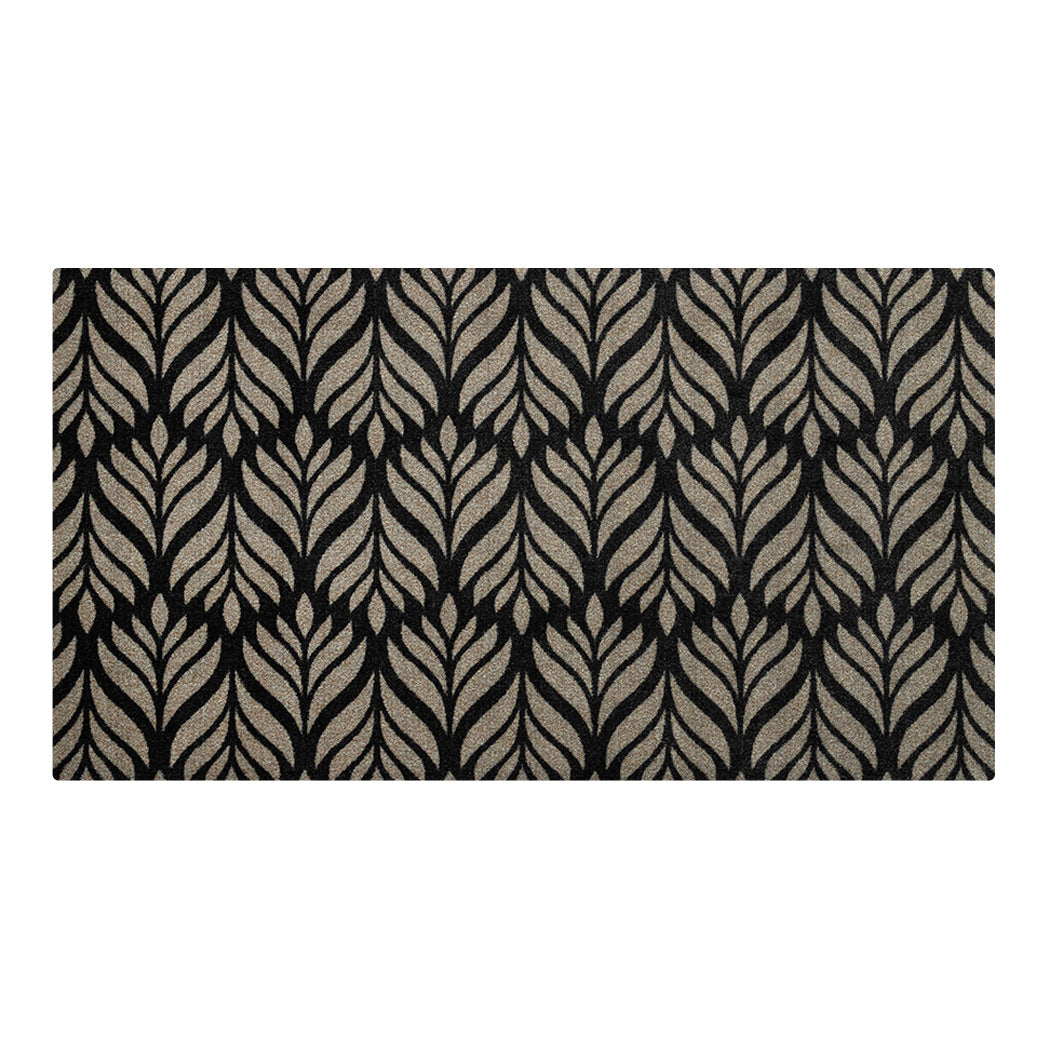 Maxcent Botanica area mat in Space Grey, medium size – features a repeating gray leaf pattern over a solid black background. The soft carpeted surface adds comfort and style, while the non-slip rubber backing provides reliable grip on hard floors.