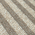 Close-up of the Maxcent Classic Stripe area mat, highlighting the textured carpet surface with alternating soft beige and grey vertical stripes. The tightly woven fibers offer a durable yet comfortable feel underfoot.