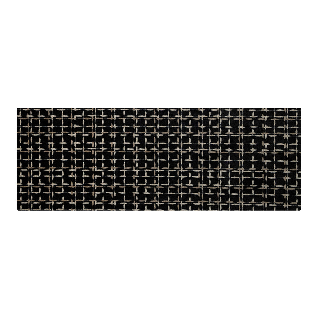 Maxcent Heritage Tweed runner rug in Inkwell – features a black background with a crosshatch pattern in light gray and tan, creating a subtle, woven grid look. The elongated shape is ideal for hallways and kitchens, and the non-slip rubber backing helps keep the mat firmly in place.