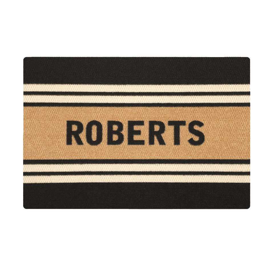 Overhead of single door Modern Moniker mat, personalized name on coir bar with two white lines on a black background.