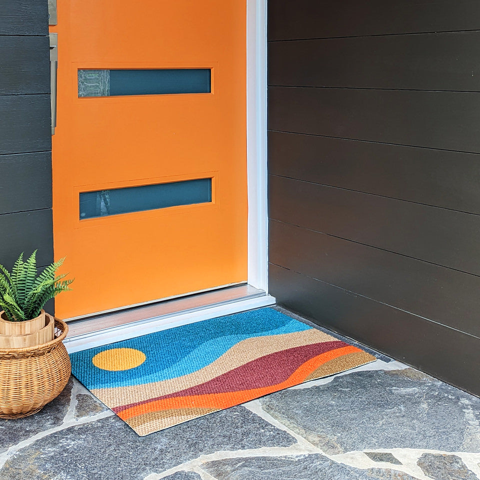 Neighburly's Mountain Sunset abstract imagery in front of a orange door that matches the orange in the mat.