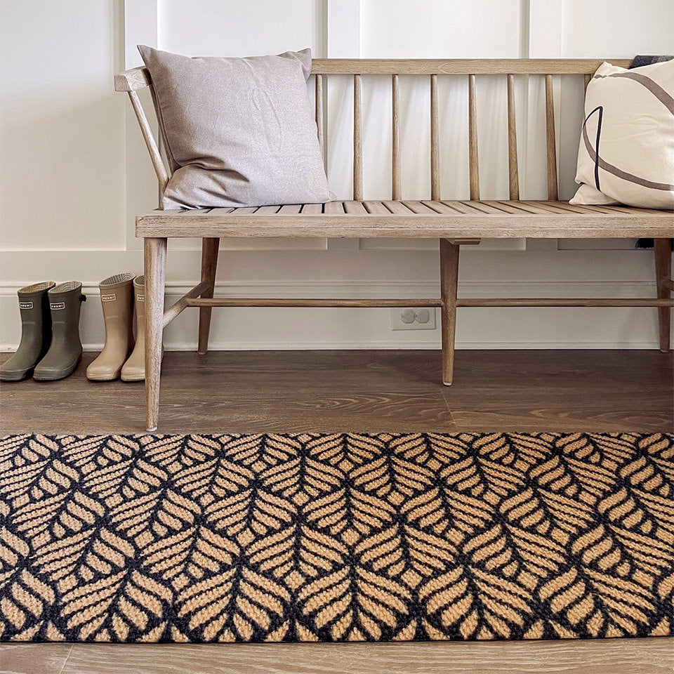 A low-profile Botanical Neighburly runner mat double door inside the entrance of a home.