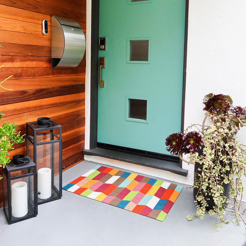 Neighburly Colorful Tulips door mat in front of a mid-century modern styled home blending the colors of the doormat.
