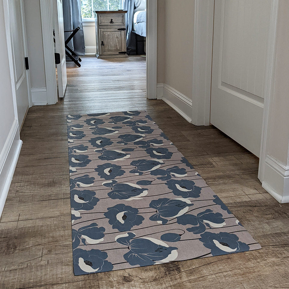 Un-Rug Poppies in strom cloud blue placed in a hallway for its low-profile and machine washable features.