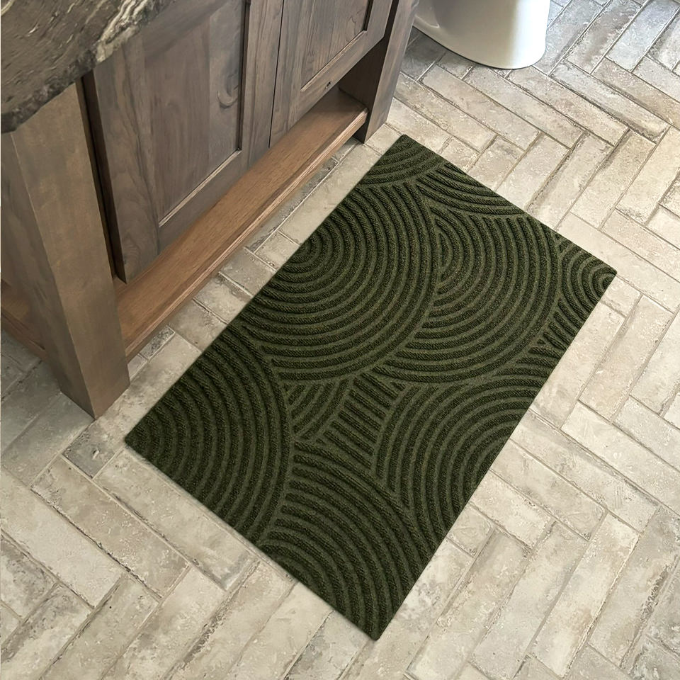 Birds eyes view of an olive green Put Your Records On mat in the bathroom on tile floors