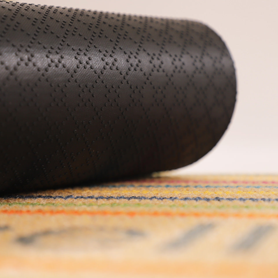 Image of the rubber backing rolled up on the vibrant Rainbow Roundabout’s non shed surface.