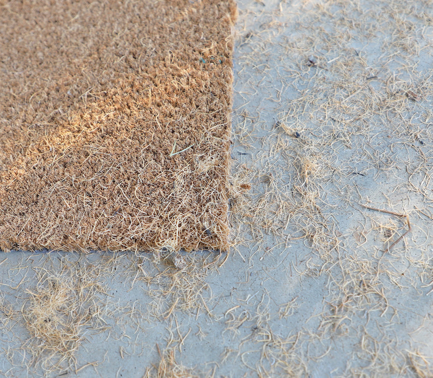Picture of a coco doormat with fiber strands that constantly shed and fall off.