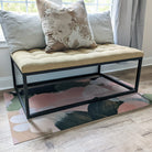 Low-profile Un-Rug mat protecting bedroom floors under a bench.