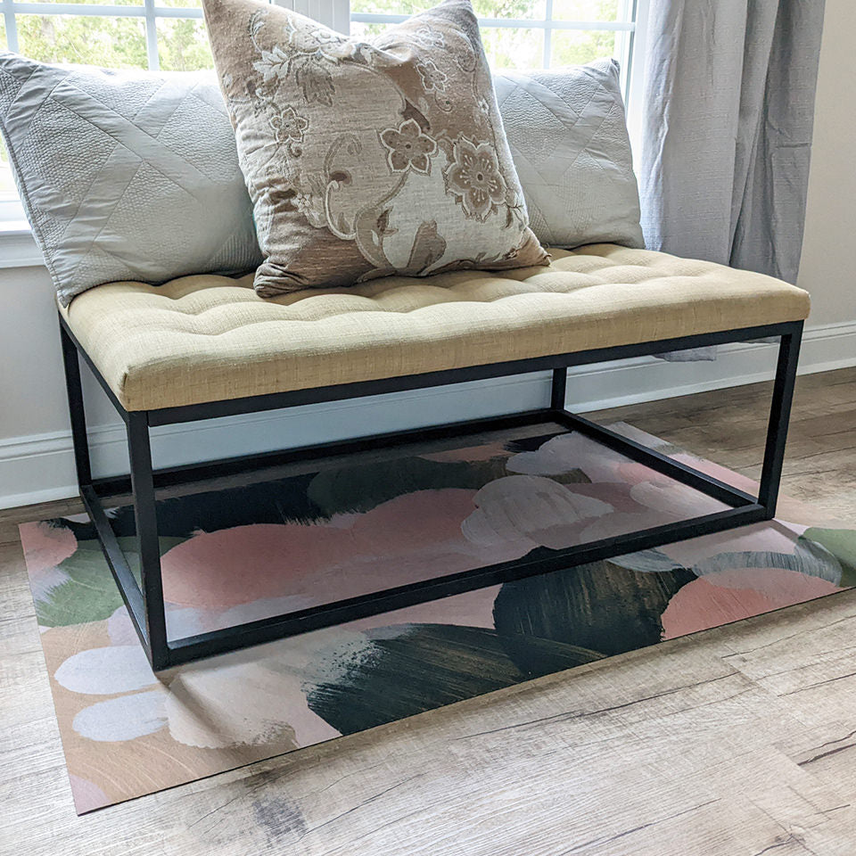 Low-profile Un-Rug mat protecting bedroom floors under a bench.
