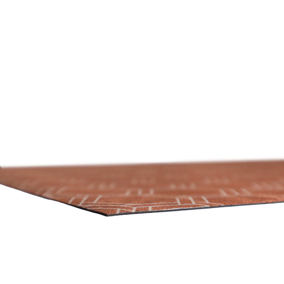 Super low profile shot of thin washable floor mat in burnt orange linen look with double honeycomb accent design in shiitake tan