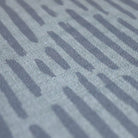 Close up of Storm cloud grey blue organic line abstract design on sea salt blue background printed on a thin low profile machine washable floor mat for indoor use.