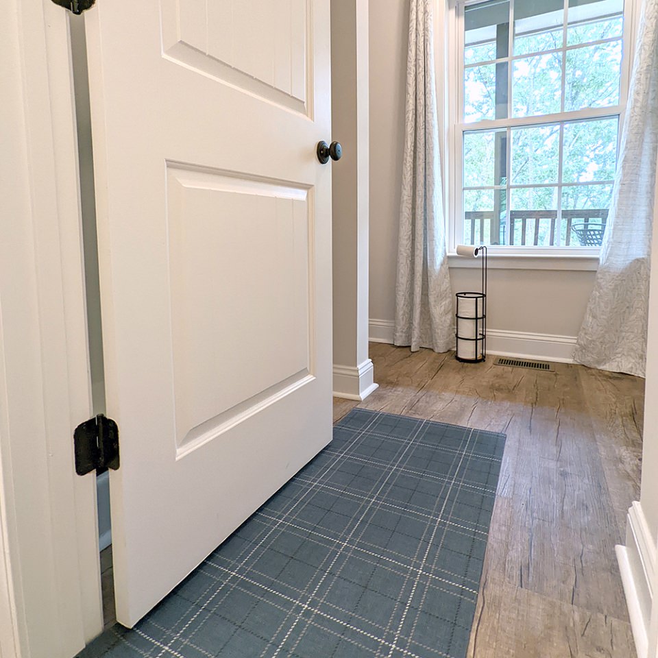 Storm Cloud blue printed linen texture with shiitake tan and urbane bronze plaid stripes on a low profile washable indoor mat