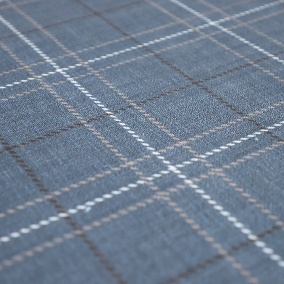 Close up of Storm Cloud blue printed linen texture with shiitake tan and urbane bronze plaid stripes on a low profile washable indoor floor mat
