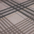 Close up of Shiitake tan printed linen texture with urbane bronze brown plaid stripes on a low profile washable indoor floor mat