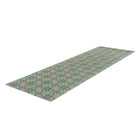 Overhead angled shot of hallway runner sized Neutral kaleidoscope pattern in aquas, apple green, and hints of orange on this low profile washable interior floor mat.