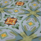 Close up of oranges, yellows, blues and greens.  Neutral kaleidoscope pattern in aquas, apple green, and hints of orange on this low profile washable interior floor mat.