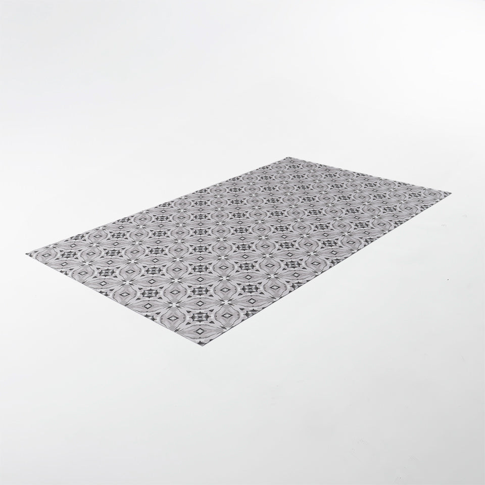 Overhead angled shot of Neutral kaleidoscope pattern in shiitake tan and urbane bronze brown with touches of storm cloud blue on this low profile washable interior floor mat.