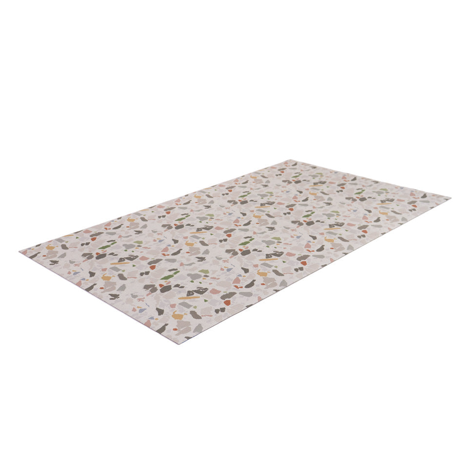 angled view of beautiful low-profile mat with light neutral background and multi-colored terrazo pattern