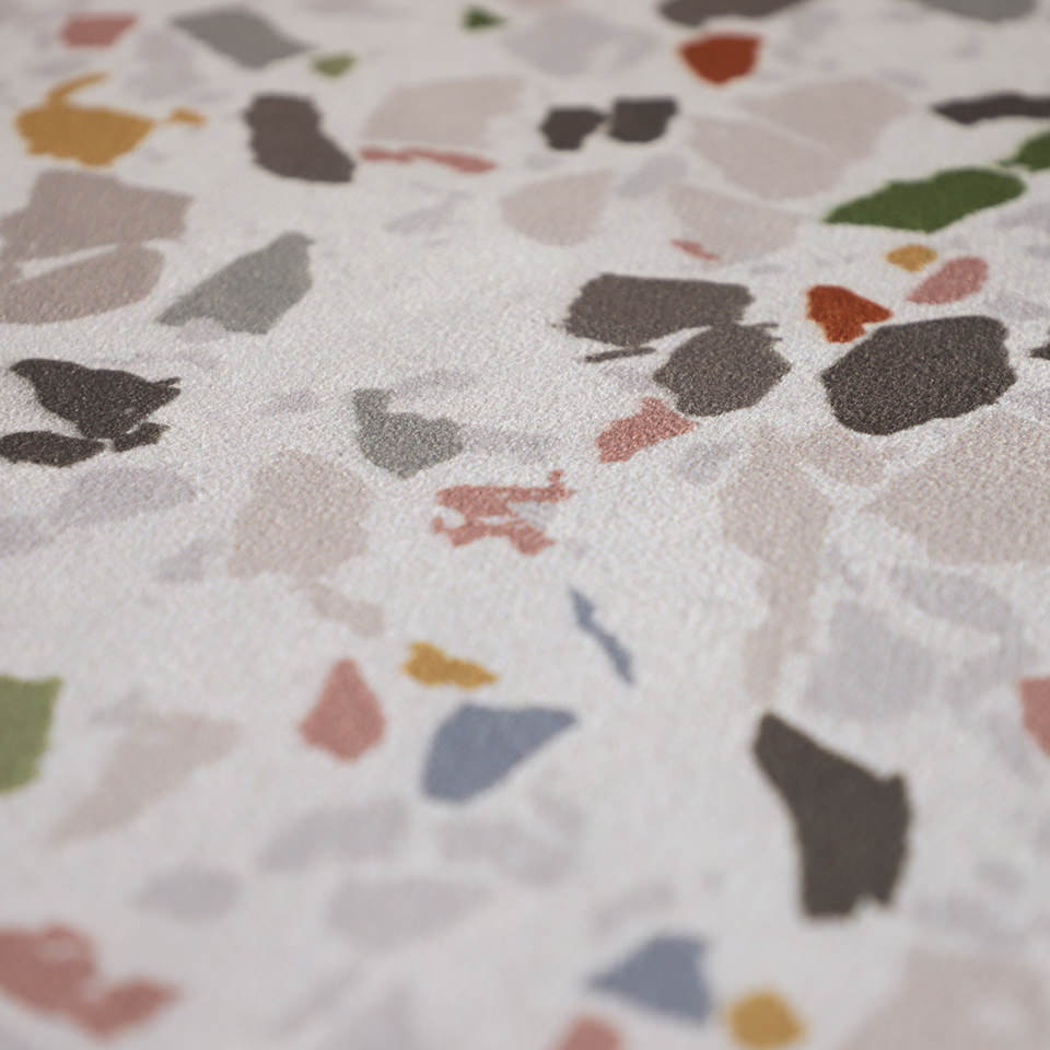 close up of soft surface with neutral light beige background and specks of colors pink, grey, green, beige