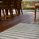 Beautiful Ticking Stripes Un-Rug in the color green on a covered porch for floor protection.