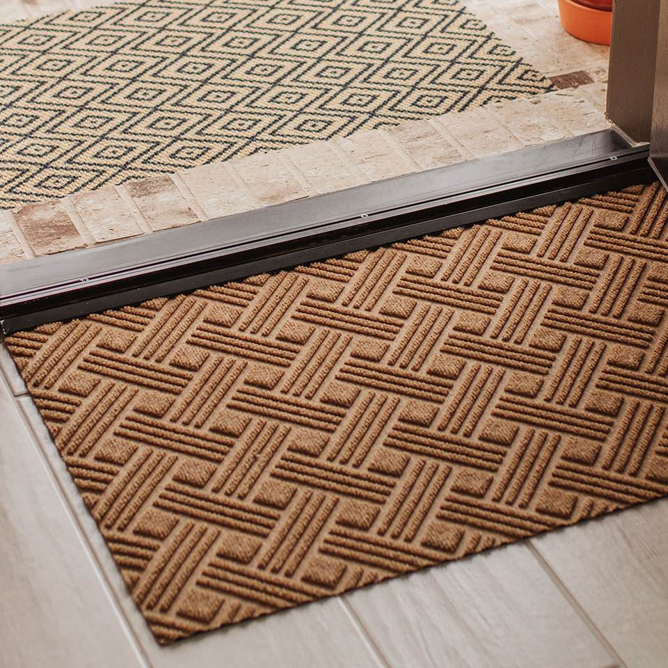 Single door WaterHog Luxe classic thatch doormat in wheat inside door entryway