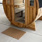 WaterHog Luxe Hourglass in wheat located outside in front of a sauna because it is all-weather.