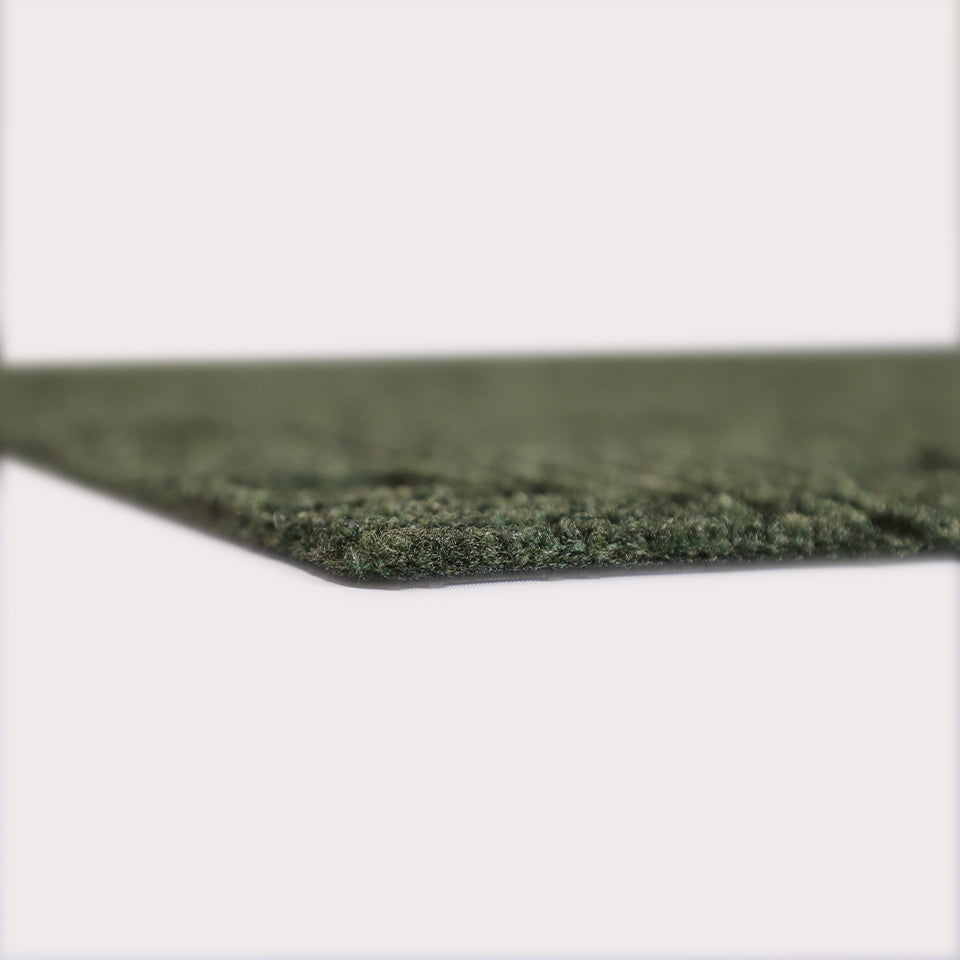 Profile corner image of the Labyrinth doormat in olive, showing the overall 3/8” height and rubber backing.