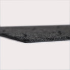 Profile corner image of the Magnolia doormat in graphite, showing the overall 3/8” height and rubber backing.